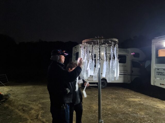 하냥살이 설맞이 캠핑 축제 참가자가 가족의 건강과 행복을 기원하는 소원지를 낙화봉 아래 정성스럽게 매달고 있다.