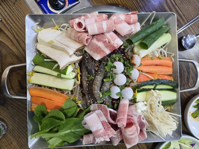 “철판 위에 핀 맛의 꽃” 행복낙지의 대표 메뉴인 낙지철판볶음. 선홍빛 대패 삼겹살과 통통한 새우, 메추리알, 그리고 신선한 각종 채소가 푸짐하게 담겨 시각적인 즐거움을 먼저 선사한다.