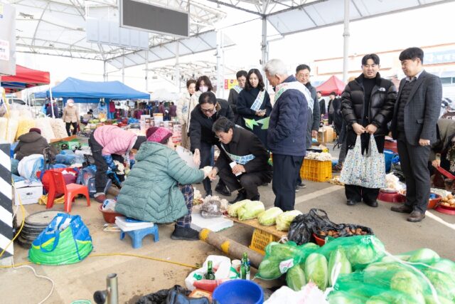 김돈곤 군수가 설을 맞아 전통시장에서 장을 보며 상인들의 애로사항을 청취하고 있다.(사진=청양군)