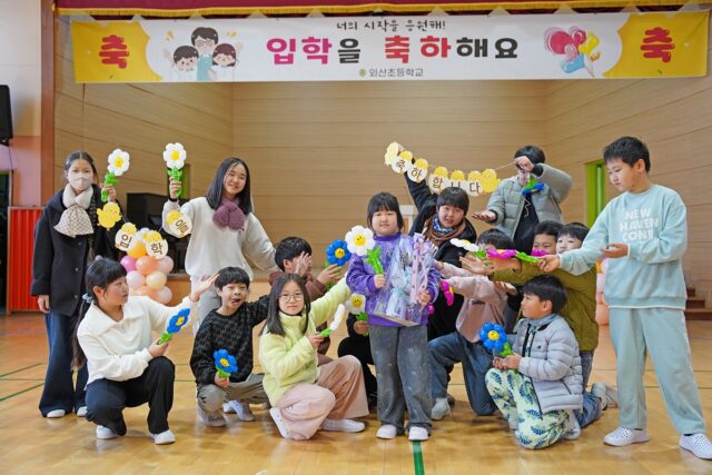 한 명의 입학생이 전교생과 교직원의 따뜻한 박수 속에서 학교의 새로운 가족이 된 것을 환영했다.