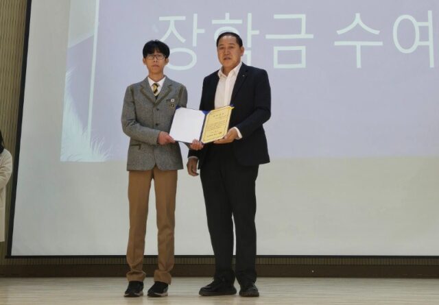 지난 3일 한국식품마이스터고등학교 2026학년도 입학식에서 박도희 홍산농업고등학교 총동창회장(오른쪽)이 신입생에게 장학증서를 전달하고 있다.