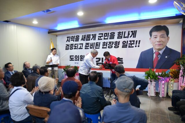 개소식을 찾은 이용우 부여군수 후보가 김영춘 후보와 뜨거운 악수를 나누며 선거 승리를 위한 연대와 격려의 마음을 전하고 있습니다.