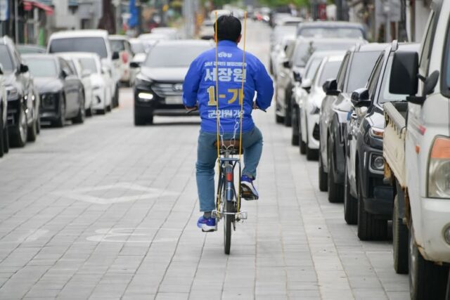 확성기를 단 유세 차량이나 로고송 대신 자전거를 타고 직접 주민들을 찾아가는 방식을 택한 서장원 후보(사진=서 후보 페이스북)