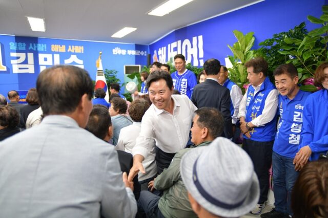 박정현 전 부여군수가 개소식 현장에서 지지자들과 밝게 웃으며 일일이 악수를 나누고있다.