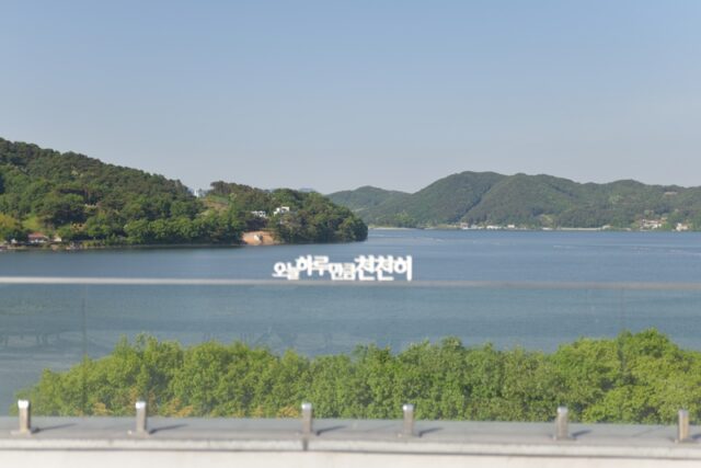 공연 장소인 '라이크레이크' 카페 너머로 펼쳐진 푸른 예당호의 전경. '오늘하루만큼천천히' 새겨진 문구와 잔잔한 호수, 멀리 보이는 산능성이가 성악의 선율과 어우러져 관객들에게 완벽한 휴식을 선사한다.