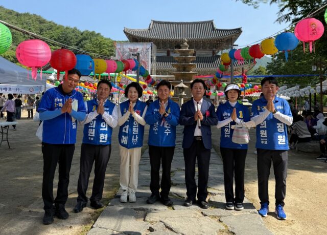 무량사를 방문한 더불어민주당 지방선거 후보자들이 경내에서 불자들을 향해 합장 인사를 올리고 있다.왼쪽부터 김경철 군의원 후보, 김의현 도의원 후보, 윤선예 군의원 후보, 김민수 부여군수 후보, 박정현 전 부여군수, 민병희 도의원(제1선거구) 후보, 서장원 군의원 후보