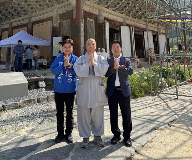 김민수 부여군수 후보(왼쪽)와 박정현 전 부여군수(오른쪽)가 무량사 주지 스님과 함께 극락전 앞 마당에서 합장하며 기념사진을 촬영하고 있다. 5월 24일.