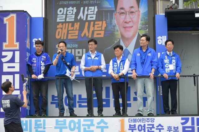 더불어민주당 박주민 의원(단상 왼쪽에서 두 번째)이 유세차 단상에 올라 자치단체장의 재량권과 재정 확보의 중요성을 역설하며 청중을 향해 마이크를 잡고 있다. 단상 위에는 노승호 군의원 후보, 문대림 의원, 김민수 후보와 장철민 의원, 양승조 전 충남지사가 함께 하고 있다.