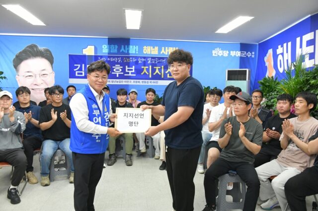 김민수 부여군수 후보(왼쪽)가 지지 선언식 직후 청년 농업인 대표로부터 69인의 서명이 담긴 지지선언 명단을 전달받으며 지지자들의 박수 속에 기념 촬영을 하고 있다.